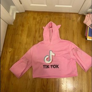 pink cropped hoodie with cat ears on the hood and tiktok label on it